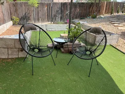 two chairs sitting on the grass in a garden at Pickleball and Hot Tub Retreat in Denver