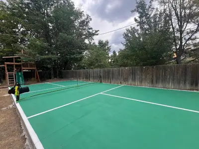 a tennis court with a net on top of it at Pickleball and Hot Tub Retreat in Denver