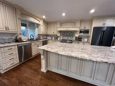 a kitchen with white cabinets and a granite counter top at Pickleball and Hot Tub Retreat in Denver