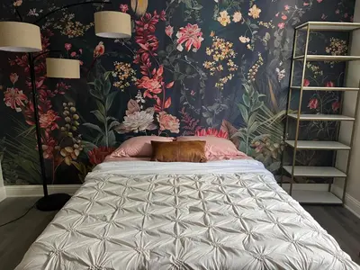 a bedroom with a large bed with a floral wallpaper at Pickleball and Hot Tub Retreat in Denver