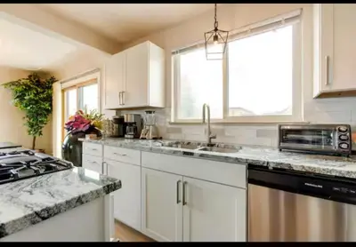 a kitchen with white cabinets and a sink and a stove at Cherry Creek Colorado in Denver