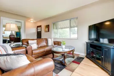 a living room with leather furniture and a flat screen tv at Cherry Creek Colorado in Denver