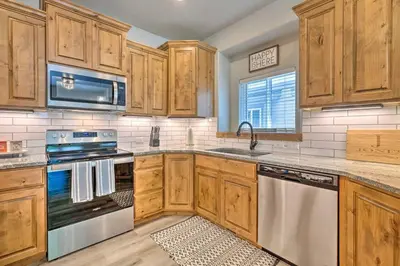 a kitchen with wooden cabinets and stainless steel appliances at Quiet Family Friendly 3 BR Near Loveland DT in Loveland