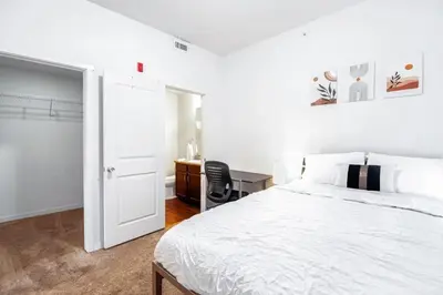a white bedroom with a white bed and a desk at Welcoming Hideaway Near UNC & Downtown in Greeley