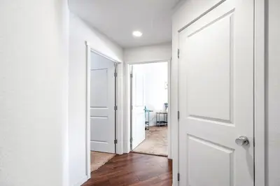 an empty hallway with a white door and a window at Welcoming Hideaway Near UNC & Downtown in Greeley