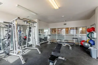 a fitness room with several treadmills and machines at Central Urban Stay with Gym in Greeley