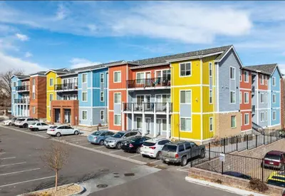 a row of houses with cars parked in a parking lot at Central Urban Stay with Gym in Greeley