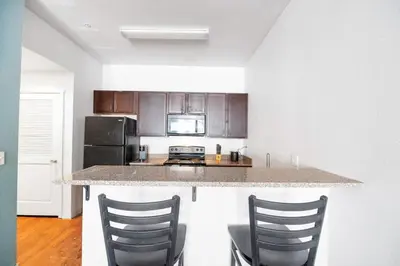 a kitchen with a counter and two chairs in it at Central Urban Stay with Gym in Greeley
