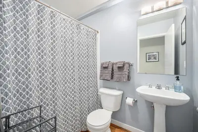 a bathroom with a white toilet and a sink at Stylish City Loft Walk to Dining & Shops in Denver