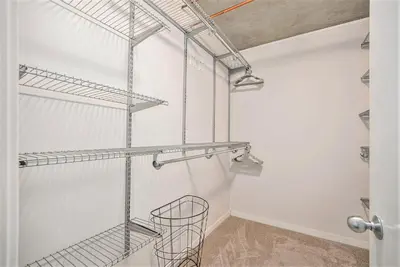 a walk in closet with white walls and metal shelves at Stylish City Loft Walk to Dining & Shops in Denver