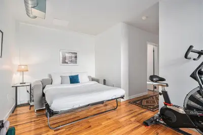 a bedroom with a bed and a treadmill at Stylish City Loft Walk to Dining & Shops in Denver