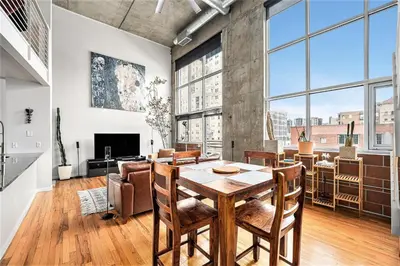 a dining room with a table and chairs and large windows at Stylish City Loft Walk to Dining & Shops in Denver
