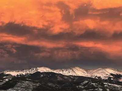 a cloudy sky over snow covered mountains with snow at Tabernash Escape in Tabernash