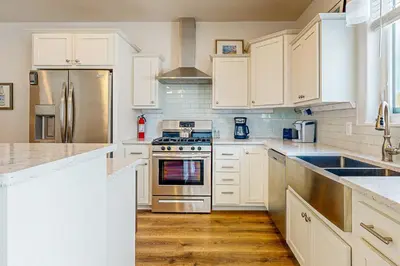 a kitchen with white cabinets and stainless steel appliances at Tabernash Escape in Tabernash