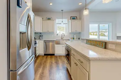 a kitchen with white cabinets and a stainless steel refrigerator at Tabernash Escape in Tabernash