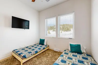 a bedroom with two beds and a flat screen tv at Tabernash Escape in Tabernash