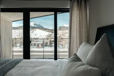 a bedroom with a view of a snowy mountain through a window at Chic Silverthorne Condo with Rocky MTN Vista Views in Silverthorne