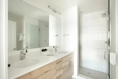 a white bathroom with a sink and a mirror at Chic Silverthorne Condo with Rocky MTN Vista Views in Silverthorne
