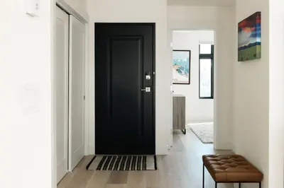 a black door in a white hallway with a stool at Chic Silverthorne Condo with Rocky MTN Vista Views in Silverthorne