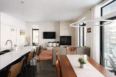 a kitchen with a dining table and a living room at Riverfront Patio - Hot Tub - Luxe Silverthorne in Silverthorne