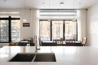 a kitchen with a sink and a dining room at Riverfront Patio - Hot Tub - Luxe Silverthorne in Silverthorne