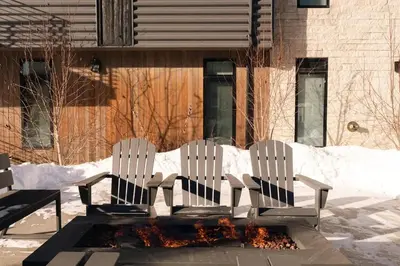 two white chairs sitting in front of a fire pit at Riverfront Patio - Hot Tub - Luxe Silverthorne in Silverthorne