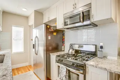 a kitchen with a stove and a refrigerator at Walk to City Park Chic Home with Hot Tub and Yard in Denver