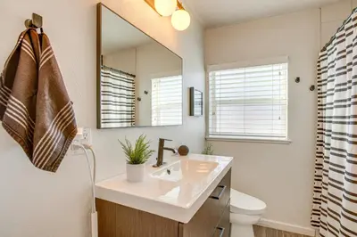 a bathroom with a sink and a mirror at Walk to City Park Chic Home with Hot Tub and Yard in Denver