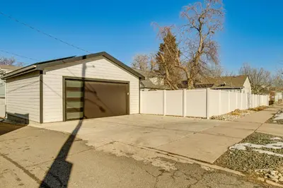 a garage with a large door in a driveway at Walk to City Park Chic Home with Hot Tub and Yard in Denver