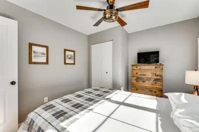 a bedroom with a bed and a ceiling fan at Steps to Estes Lake Mtn-View Hideaway with Hot Tub! in Estes Park