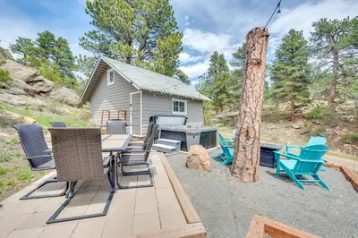 a backyard with a table and chairs and a grill at Steps to Estes Lake Mtn-View Hideaway with Hot Tub! in Estes Park
