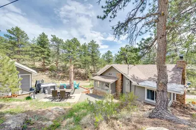 a cabin in the woods with a table and chairs at Steps to Estes Lake Mtn-View Hideaway with Hot Tub! in Estes Park