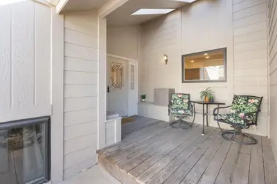 a porch with two chairs and a table on a wooden floor at Mid-Century Mod Retreat with Lakefront Trails, Quiet in Fort Collins