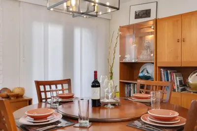 a dining room table with a bottle of wine on it at Mid-Century Mod Retreat with Lakefront Trails, Quiet in Fort Collins