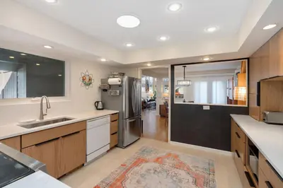 a kitchen with a sink and a refrigerator at Mid-Century Mod Retreat with Lakefront Trails, Quiet in Fort Collins