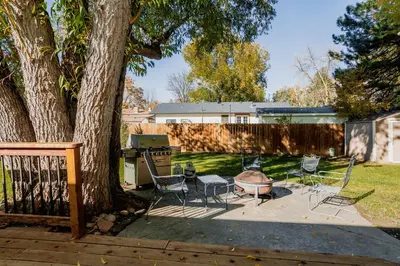 a group of chairs and a grill next to a tree at The Rustic Retreat, Pet Friendly with Fenced Yard in Fort Collins