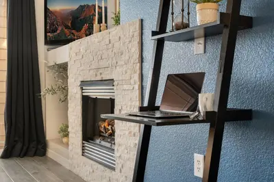 a fireplace in a living room with a blue wall at Timberline Retreat - King Bed, Fireplace & Pool! in Fort Collins