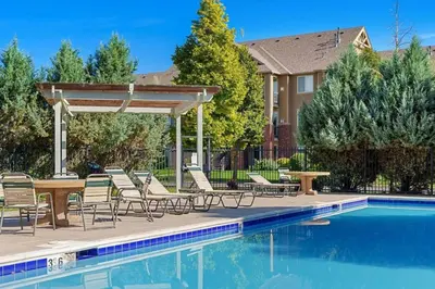 a pool with chairs and a table next to a house at Timberline Retreat - King Bed, Fireplace & Pool! in Fort Collins