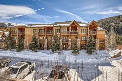 a large lodge in the snow with cars parked in front at 5959 Hidden River Lodge condo in Keystone