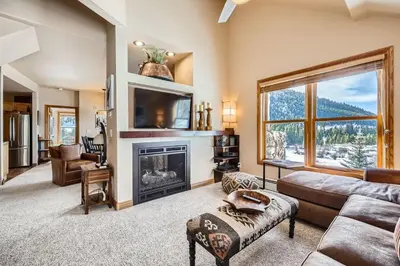 a living room with a fireplace and a tv at 5959 Hidden River Lodge condo in Keystone