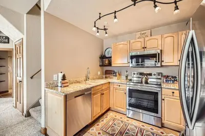 a kitchen with wooden cabinets and a refrigerator at 5959 Hidden River Lodge condo in Keystone