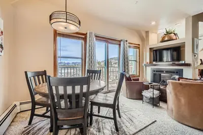 a dining room with a table and chairs and a fireplace at 5959 Hidden River Lodge condo in Keystone