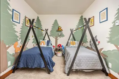 two beds in a bedroom with a forest themed wall at Ridge View Retreat - Panoramic Views and Hot Tub in Nederland