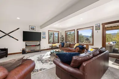 a living room with leather furniture and a flat screen tv at Ridge View Retreat - Panoramic Views and Hot Tub in Nederland