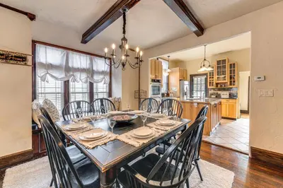 a dining room with a table and chairs and a kitchen at Historical Dtwn Loveland Home with Wraparound Porch! in Loveland