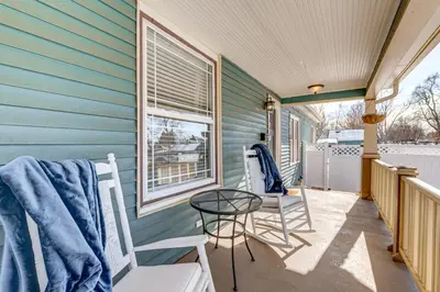 a patio with chairs and a table on a house at Historical Dtwn Loveland Home with Wraparound Porch! in Loveland