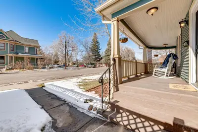 a porch of a house with snow on the ground at Historical Dtwn Loveland Home with Wraparound Porch! in Loveland
