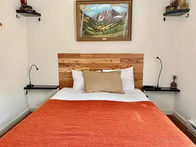 a bedroom with a bed with an orange blanket at Skiers Cabin at Base Camp Lodging Company in Dumont