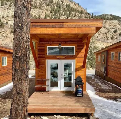 a log cabin with a porch and a door at Skiers Cabin at Base Camp Lodging Company in Dumont