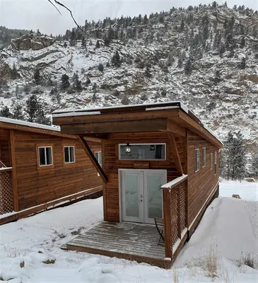 a log cabin with a door in the snow at Skiers Cabin at Base Camp Lodging Company in Dumont